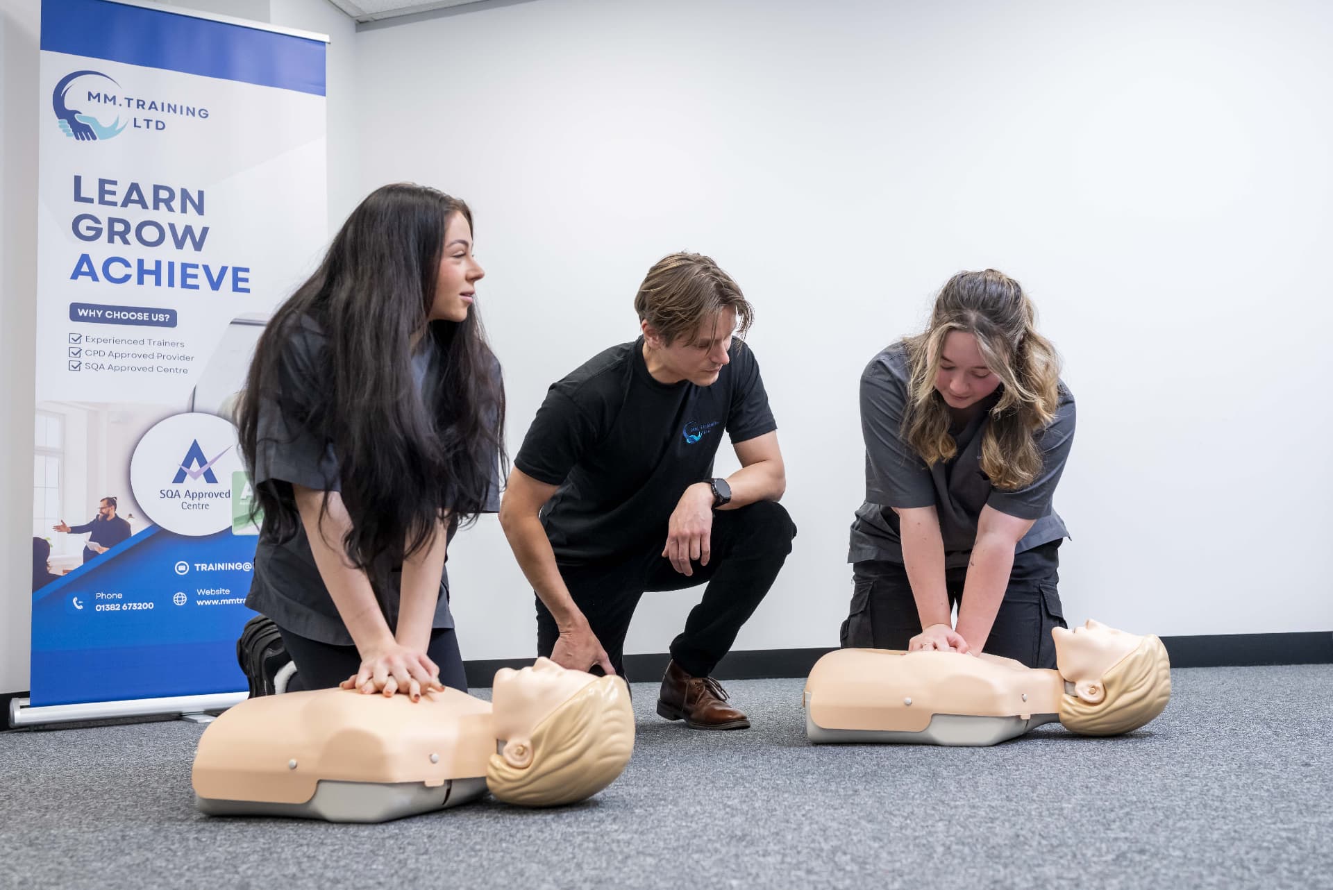 MMTraining trainer guiding delegates through CPR practice on manikins